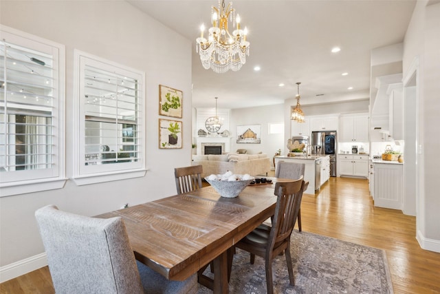 2005 Tremont Blvd, Mckinney, TX 75071 - dining room with a chandelier, light wood-style flooring, recessed lighting, baseboards, and a fireplace