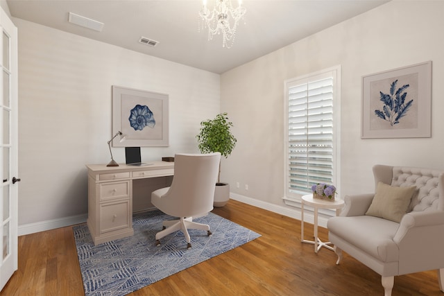 office area with hardwood / wood-style floors and a notable chandelier