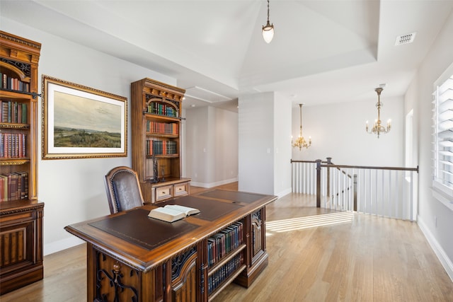 office space featuring light hardwood / wood-style floors, an inviting chandelier, plenty of natural light, and lofted ceiling