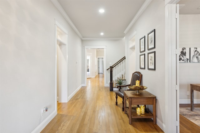 corridor featuring light wood-type flooring and crown molding