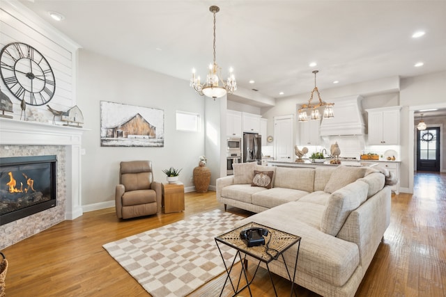 living room with light wood-type flooring and a stone fireplace