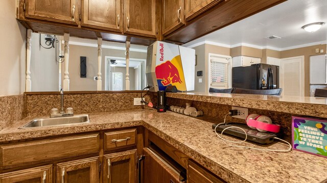 kitchen with black refrigerator, ceiling fan, and ornamental molding