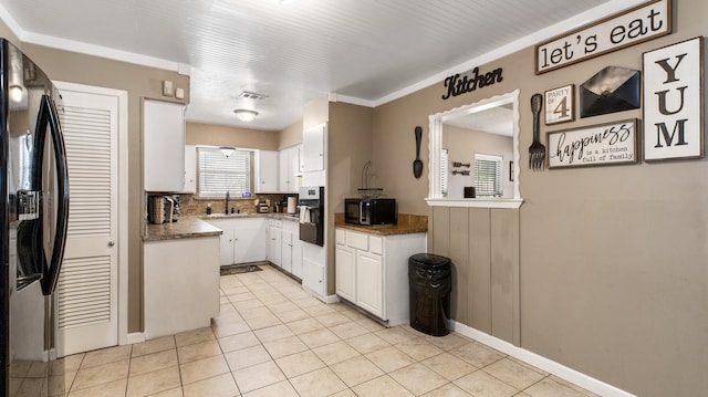 kitchen featuring white cabinetry, sink, light tile patterned floors, and stainless steel appliances