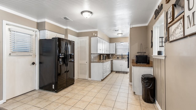 kitchen featuring white cabinetry, black fridge with ice dispenser, ornamental molding, and sink