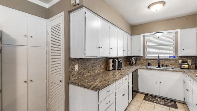 kitchen featuring white cabinets, tasteful backsplash, light tile patterned flooring, and sink