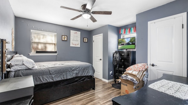 bedroom featuring multiple windows, ceiling fan, and hardwood / wood-style flooring