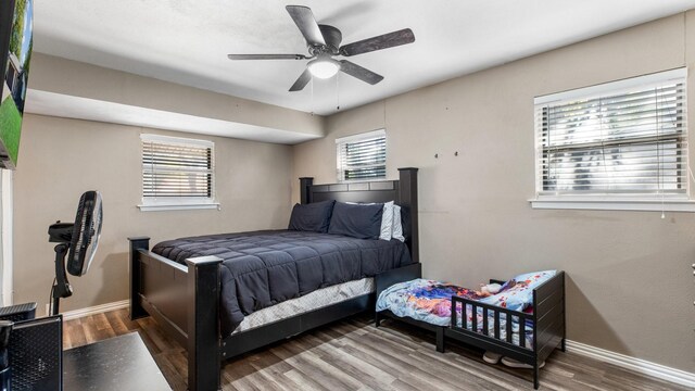 bedroom featuring multiple windows, ceiling fan, and hardwood / wood-style floors