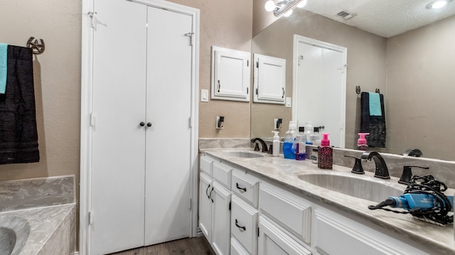 bathroom featuring vanity, wood-type flooring, and a textured ceiling