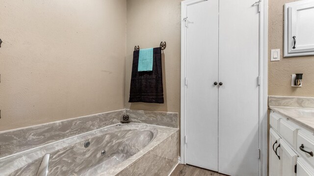 bathroom featuring hardwood / wood-style flooring, vanity, and a bathtub