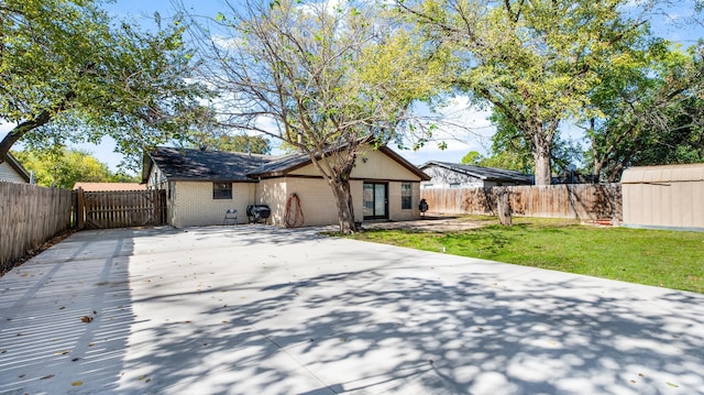 back of property featuring a patio area and a yard