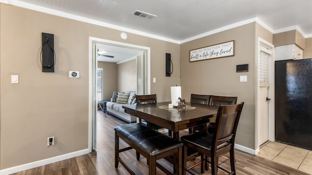 dining space with crown molding, ceiling fan, and hardwood / wood-style flooring