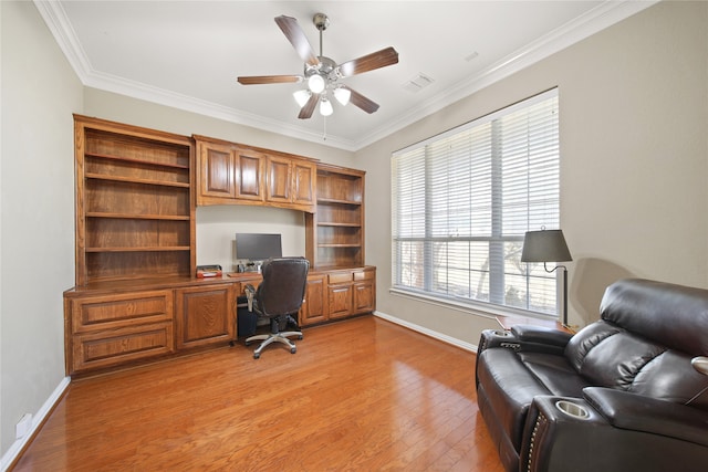 home office featuring ceiling fan, light hardwood / wood-style flooring, built in desk, and ornamental molding