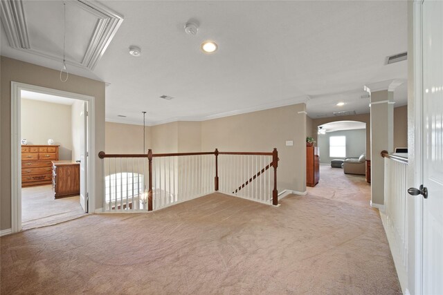 corridor with crown molding and light carpet