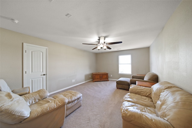 carpeted living room featuring ceiling fan and a textured ceiling