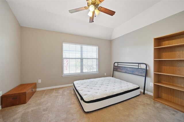 bedroom featuring ceiling fan, light carpet, and vaulted ceiling