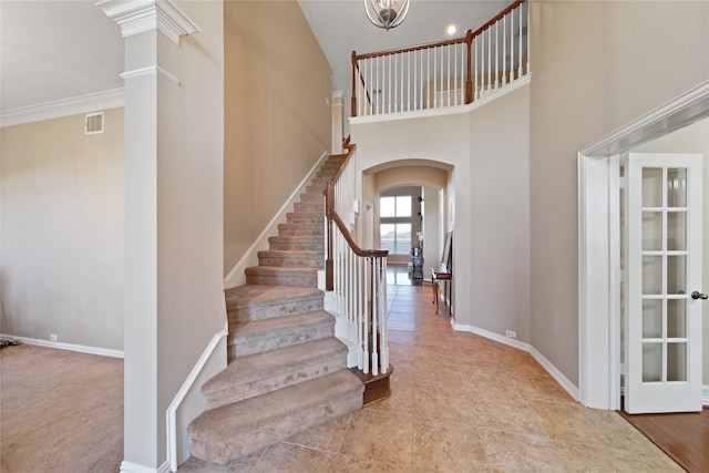 stairs with carpet, ornate columns, and crown molding