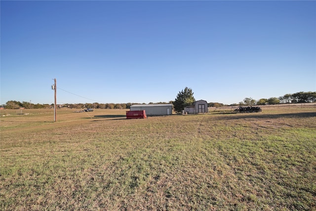 view of yard featuring a rural view and a storage unit