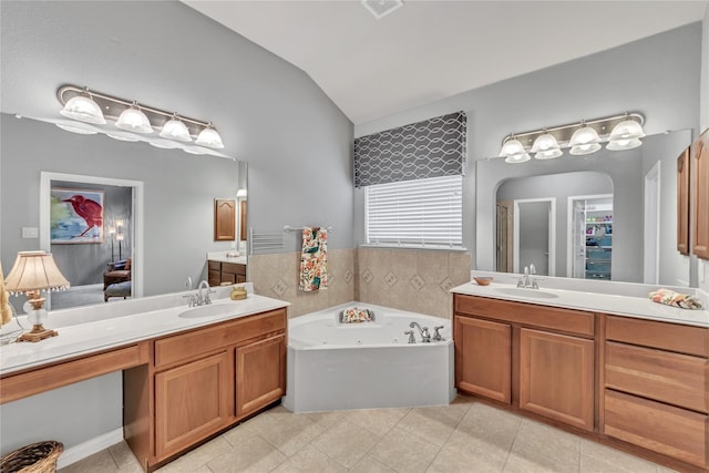 bathroom featuring tile patterned floors, vanity, a bathing tub, and vaulted ceiling