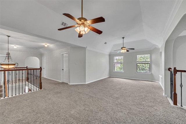 carpeted empty room featuring vaulted ceiling, ceiling fan, and crown molding