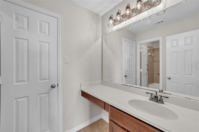 bathroom featuring tile patterned floors, tiled shower / bath combo, and vanity