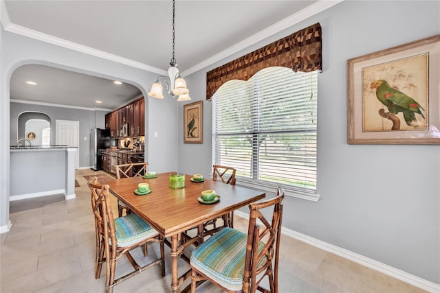 dining space with crown molding, sink, light tile patterned floors, and an inviting chandelier