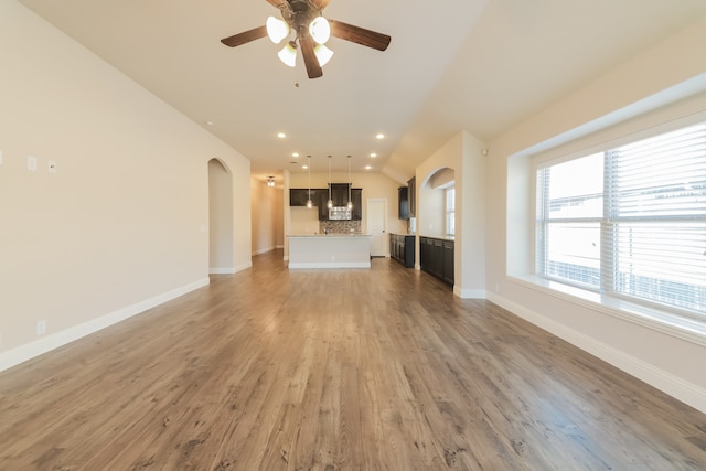 unfurnished living room featuring hardwood / wood-style floors, ceiling fan, and lofted ceiling