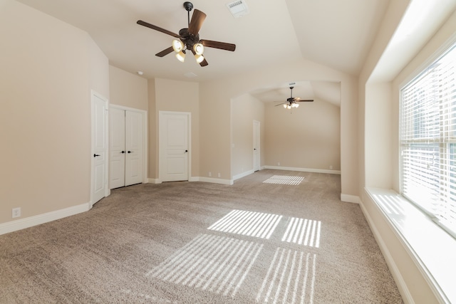 carpeted spare room featuring vaulted ceiling and ceiling fan