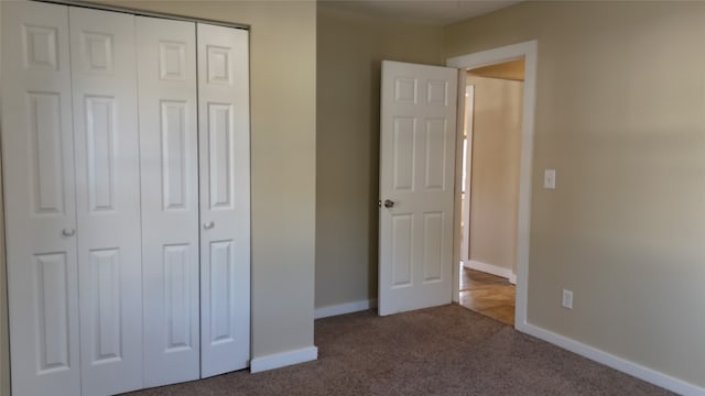 unfurnished bedroom with a closet and dark carpet