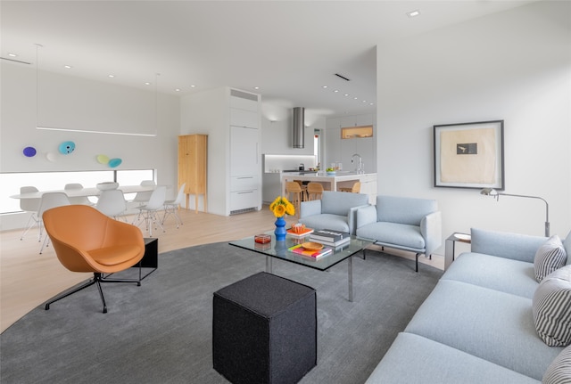 living room with light wood-type flooring and sink