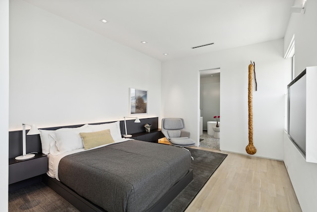 bedroom with light hardwood / wood-style floors and connected bathroom