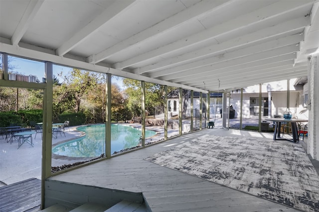 sunroom featuring beam ceiling