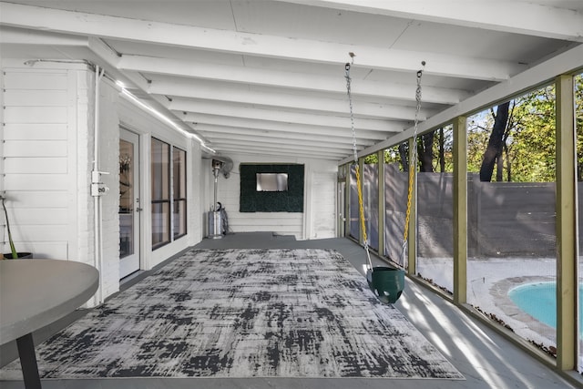 unfurnished sunroom featuring vaulted ceiling with beams