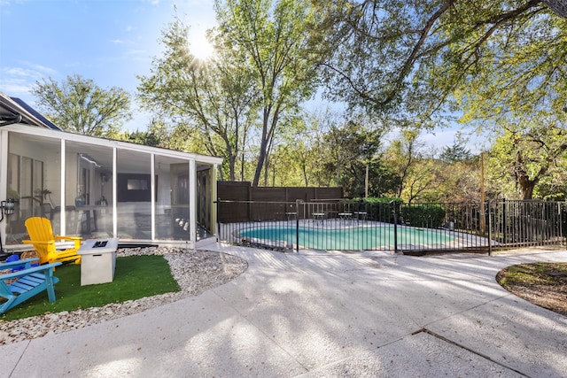 view of swimming pool with a sunroom and a patio area