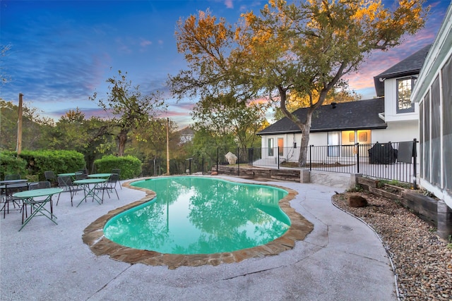 pool at dusk featuring a patio area