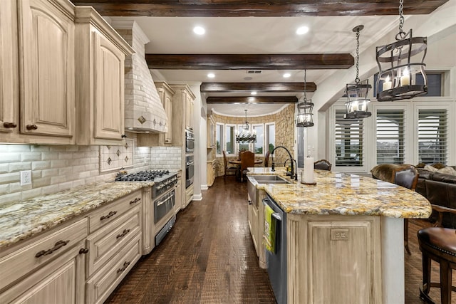 kitchen featuring beamed ceiling, a kitchen island with sink, and light brown cabinetry