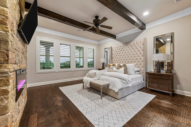 bedroom featuring ceiling fan, a stone fireplace, dark hardwood / wood-style flooring, beamed ceiling, and crown molding