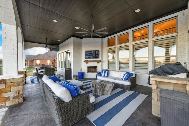 view of patio featuring an outdoor living space with a fireplace and ceiling fan