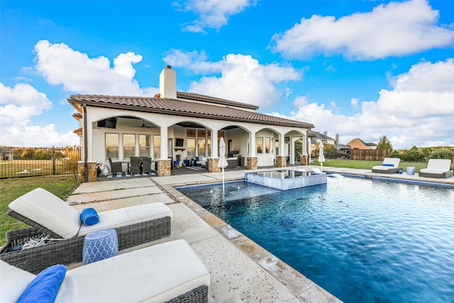 view of pool featuring pool water feature, an outdoor living space, a hot tub, and a patio area