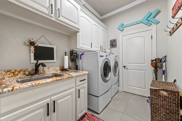 clothes washing area featuring cabinets, ornamental molding, sink, washer and dryer, and light tile patterned floors