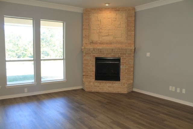 unfurnished living room with dark hardwood / wood-style flooring, ornamental molding, and a fireplace