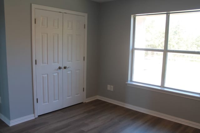 unfurnished bedroom featuring dark hardwood / wood-style floors and a closet