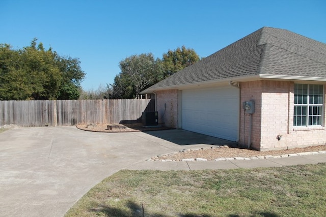 view of home's exterior with central AC and a garage