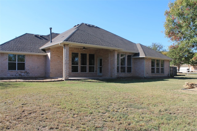 rear view of house featuring a lawn and ceiling fan