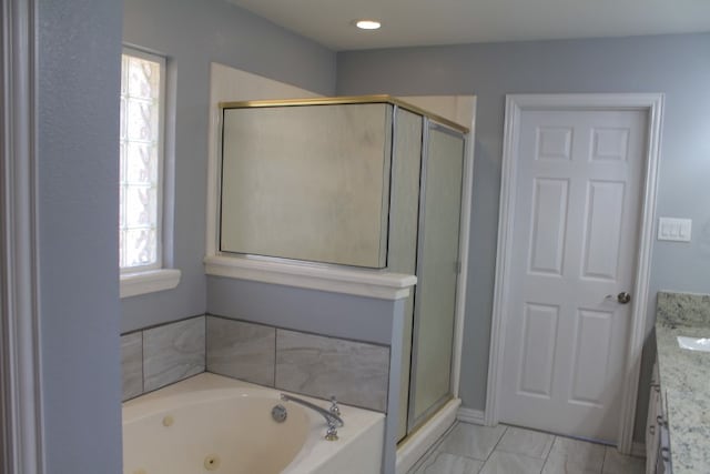 bathroom with vanity and shower with separate bathtub