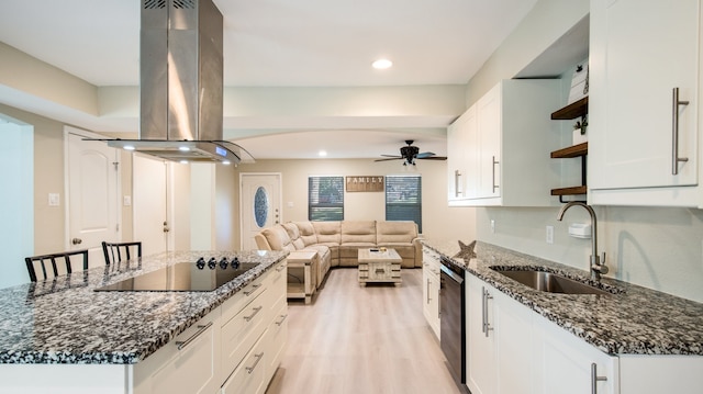 kitchen with white cabinetry, island range hood, dark stone counters, and black appliances