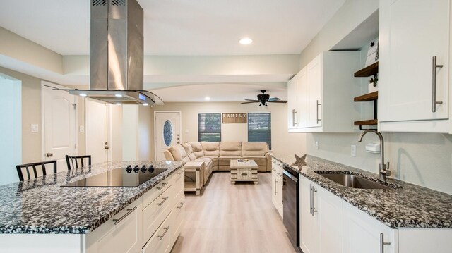 kitchen with white cabinetry, island range hood, dark stone counters, and black appliances