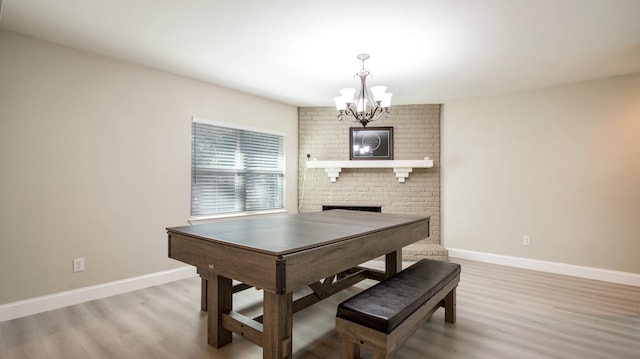 dining space featuring a fireplace, hardwood / wood-style floors, and a chandelier