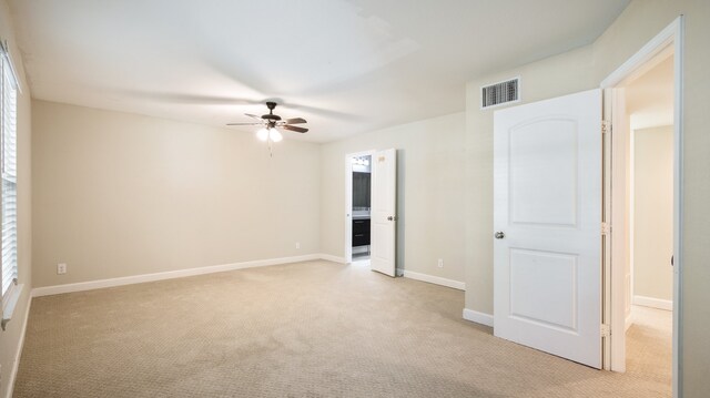 carpeted spare room with ceiling fan