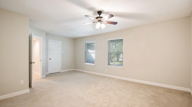 carpeted spare room featuring ceiling fan