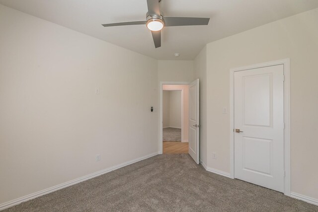 unfurnished bedroom with baseboards, a ceiling fan, and light colored carpet